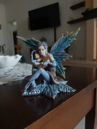 Fatina con libro e ali blu un'ala è un po' rotta