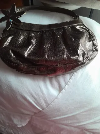 Bolso marrón y dorado con flor