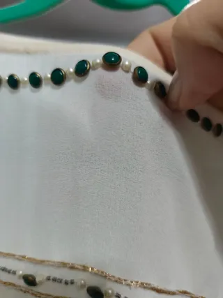 Blusa blanca con detalles dorados.