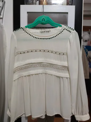 Blusa blanca con detalles dorados.