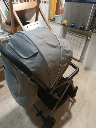 Silla de paseo gris y negra, con capota, respaldo