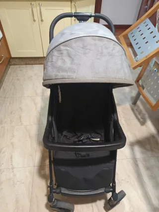 Silla de paseo gris y negra, con capota, respaldo