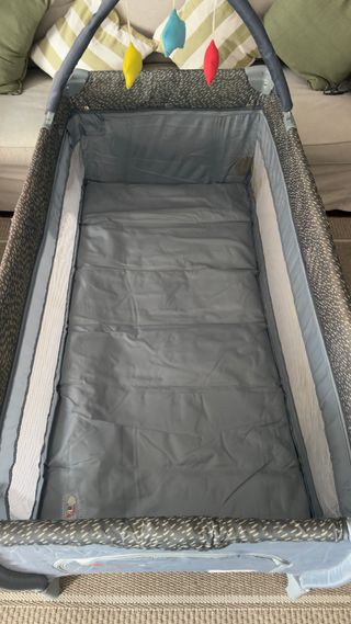 Cuna de viaje gris con móvil