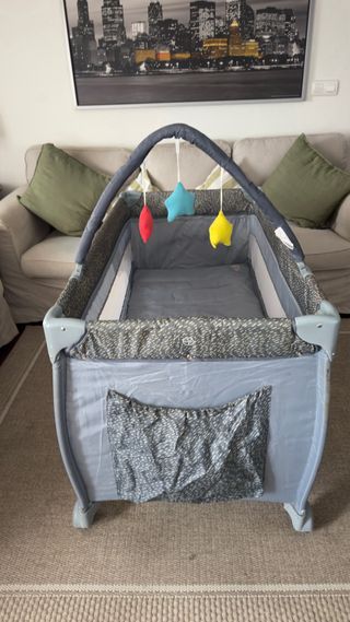 Cuna de viaje gris con móvil