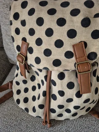 Mochila beige y negra con lunares