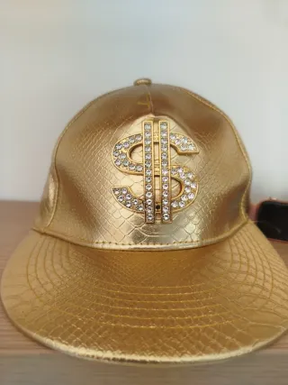 Gorra dorada con diseño de dólar