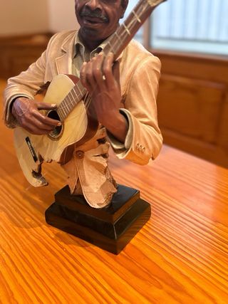 Estatua de músico con guitarra