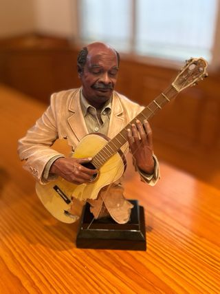 Estatua de músico con guitarra