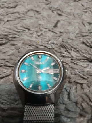 Reloj plateado con esfera turquesa