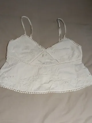 Top blanco con bordados y pompones