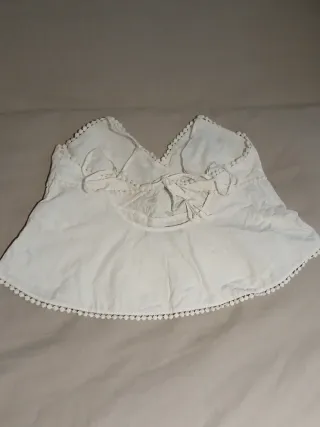 Top blanco con bordados y pompones