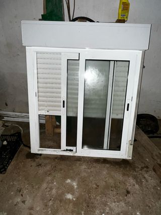 Ventana corredera blanca con persiana y rejas