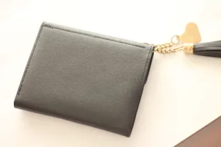 Cartera negra con detalle de corazón y borla