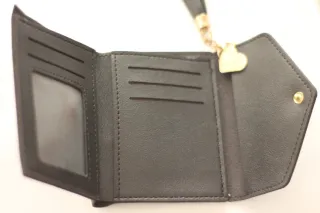 Cartera negra con detalle de corazón y borla