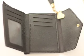 Cartera negra con detalle de corazón y borla