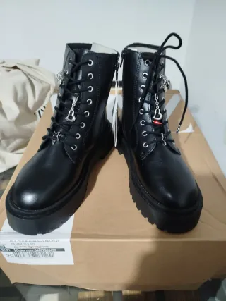 Botas con cordones en su frontal y detalle charms