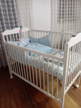 Cuna de bebé blanca con ruedas