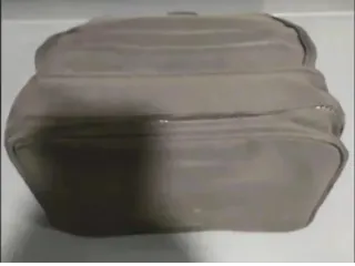 Bolso de mano gris con cremallera.