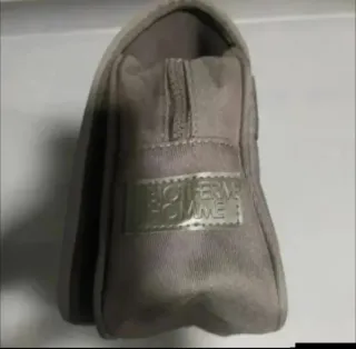 Bolso de mano gris con cremallera.