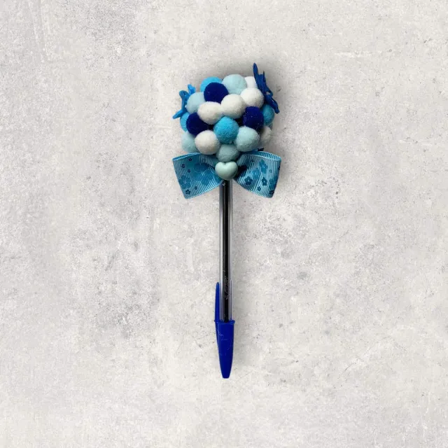 Bolígrafo decorado con pompones y lazo