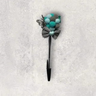 Bolígrafo decorado con pompones y lazo