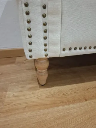 Sofá baúl beige con patas de madera