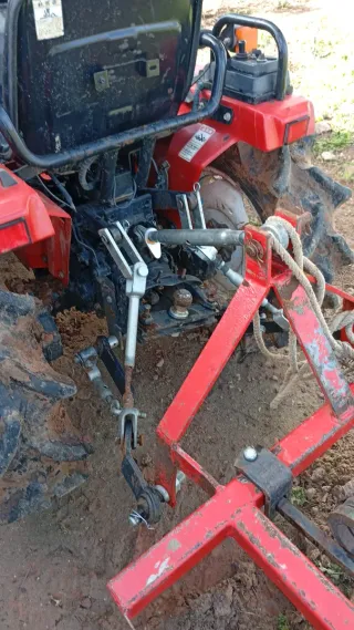 Tractor rojo con pala frontal