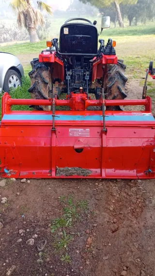 Tractor rojo con pala frontal