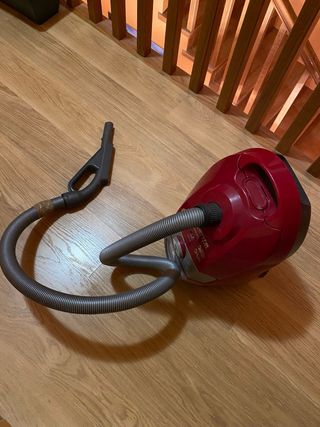 Aspiradora roja con manguera y accesorio