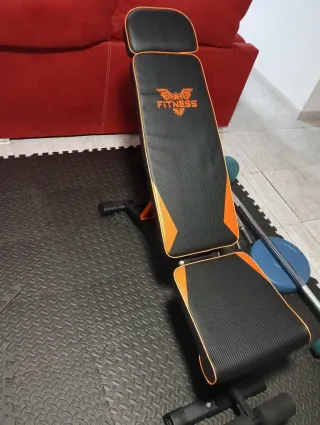 Banco de ejercicios con barra y mancuernas