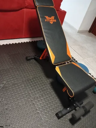 Banco de ejercicios con barra y mancuernas