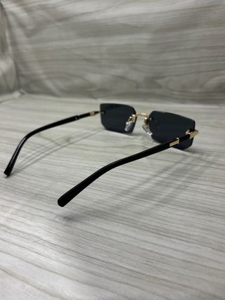 Occhiali da sole neri con montatura dorata