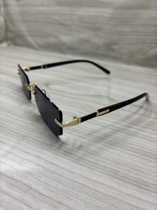 Occhiali da sole neri con montatura dorata