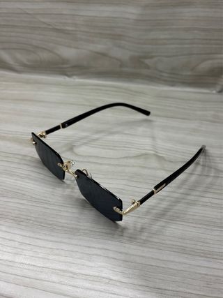 Occhiali da sole neri con montatura dorata