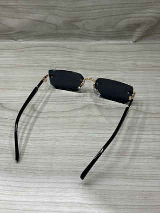 Occhiali da sole neri con montatura dorata