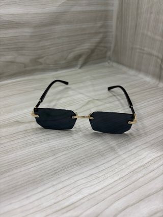 Occhiali da sole neri con montatura dorata