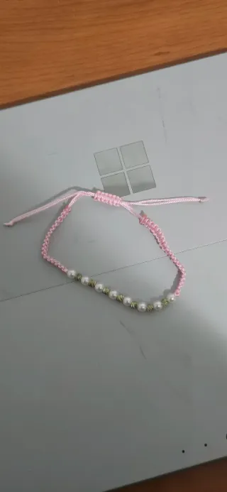Pulsera rosa con perlas y detalles plateados