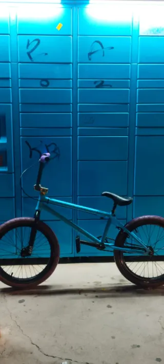Bicicleta BMX azul con manillar morado