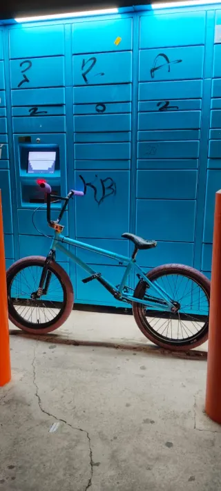 Bicicleta BMX azul con manillar morado