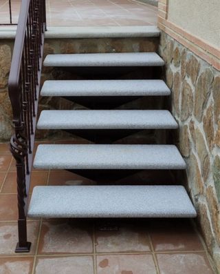 Escalera metálica con peldaños de granito
