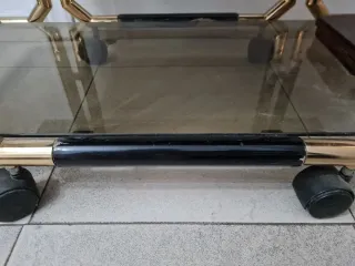 Mesa camarera de madera lacada, metal y vidrio.