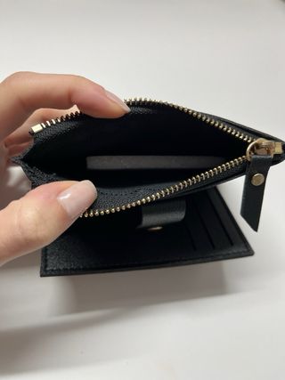 Cartera negra con cremallera y botón