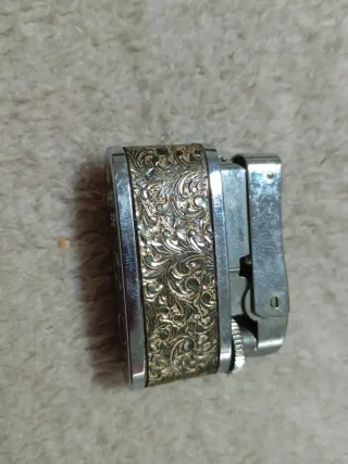 Lote coleccionista: mechero, moneda y pulsera.