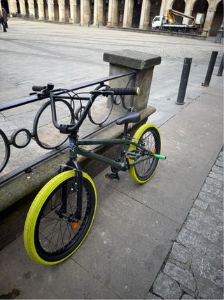 Bicicleta BMX verde con ruedas amarillas