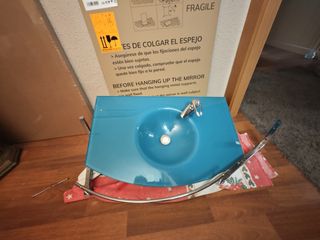 Lavabo cristal azul con grifo y un espejo