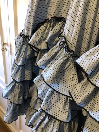 Traje de flamenca gris con lunares en negro.