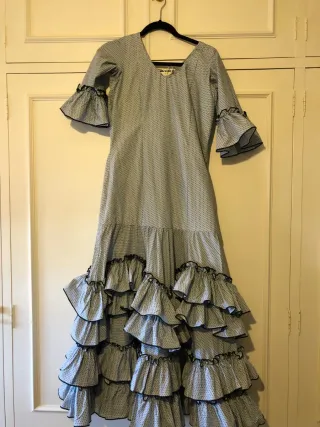 Traje de flamenca gris con lunares en negro.