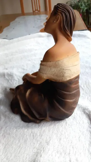 Figura mujer joven sentada pelo recogido