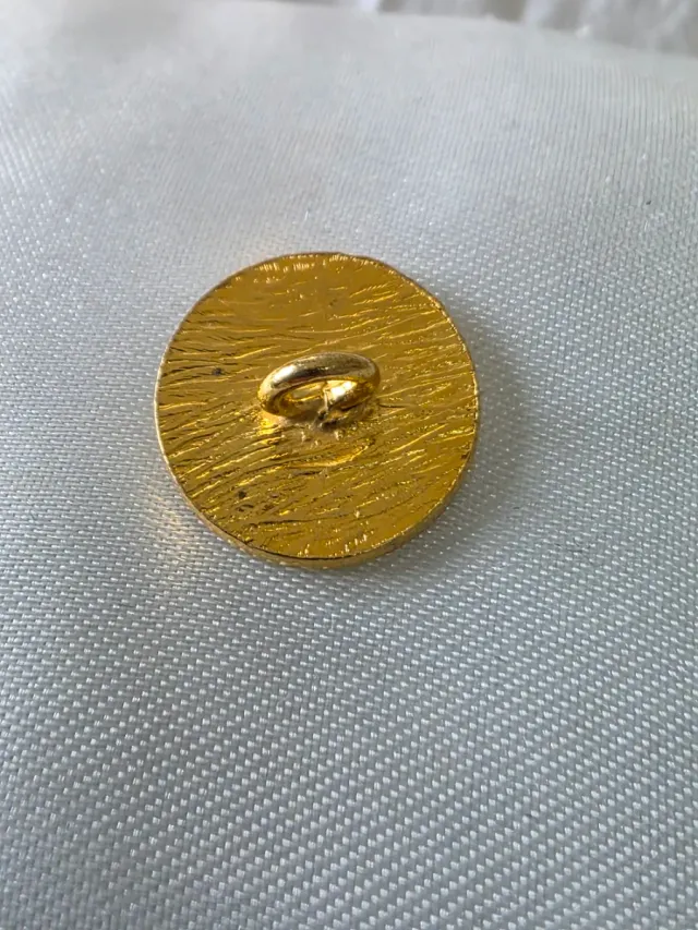 Botón dorado con diseño