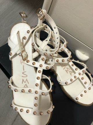 Sandalias blancas y doradas con tachuelas